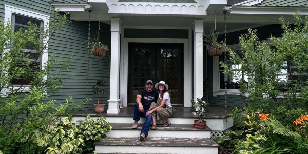 Farm owners on the front porch of the farmhouse