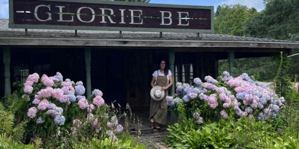 store owner in front of an old country farm store.