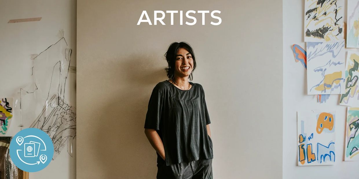 Young woman in front of a canvas with the word 'ARTISTS' 