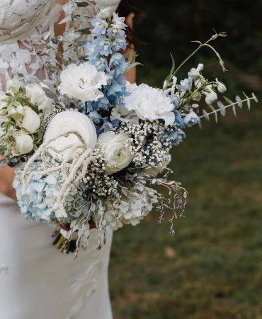 Elegant bridal bouquet with white and blue flowers.