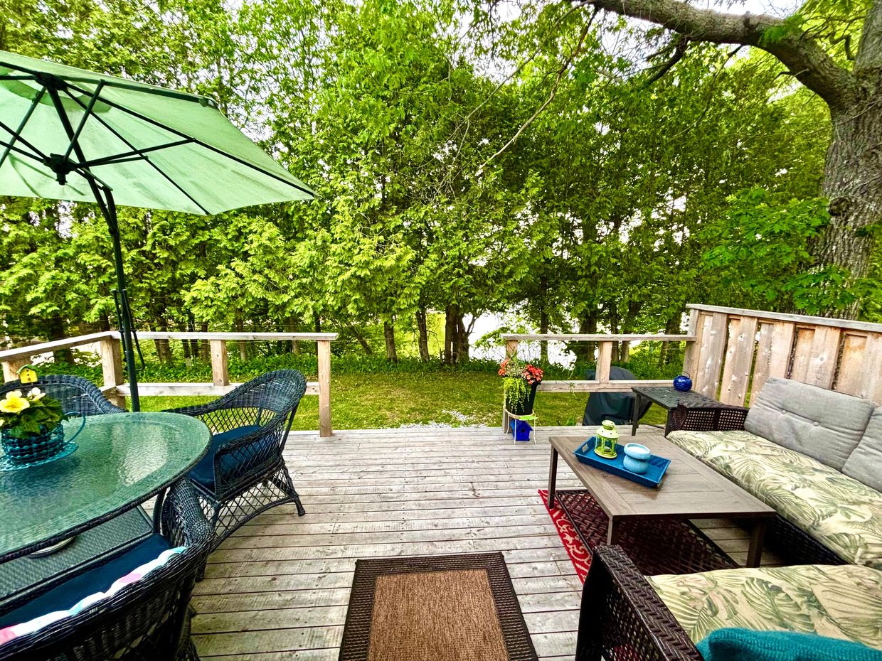 Cozy river view deck with sectional, table for 4, umbrella for shade and two steps down to the bbq. 