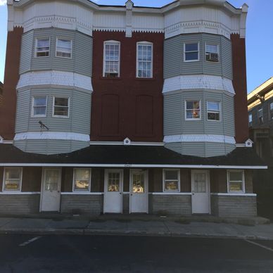 Old building with 'For Rent' signs on the windows.