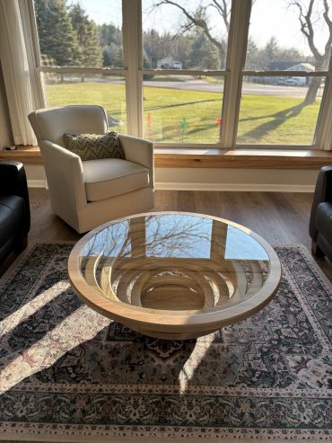 Modern living room with a glass coffee table and beige armchair.