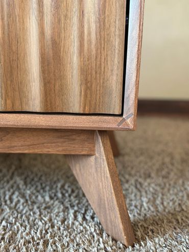 Close-up of wooden furniture leg and corner.