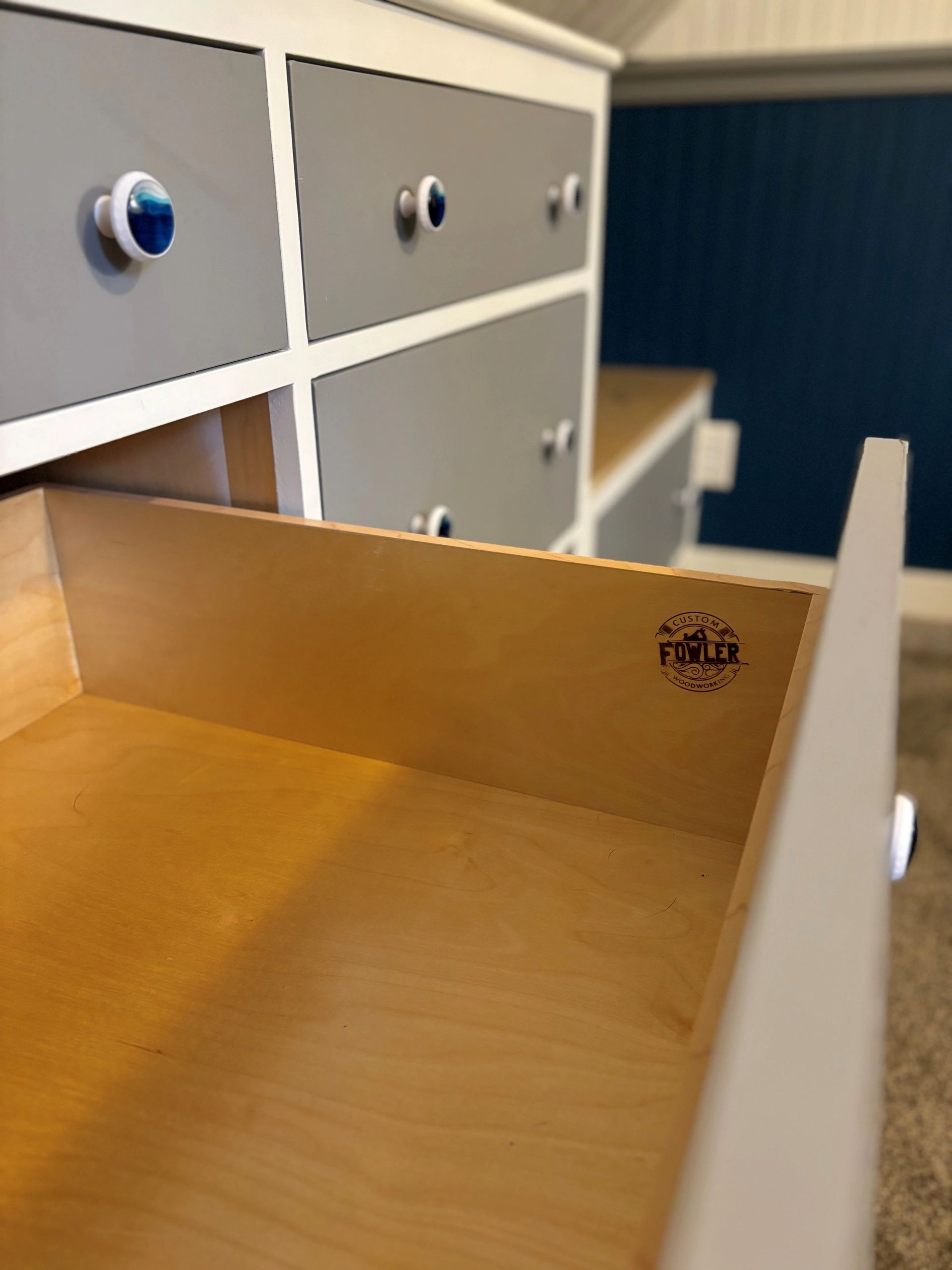 Custom wooden drawers with blue and white knobs.