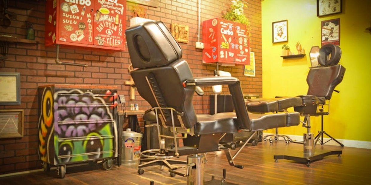 Black leather tattoo chairs in a brightly lit studio.