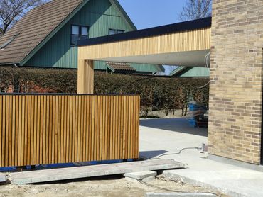 Opført carport og hegn i træ – udført af Fugmann Byg ApS i moderne og holdbart design.