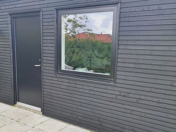Nyopført eller renoveret facade med sortmalet træbeklædning og termovindue – moderne og vedligeholdelsesvenlig løsning