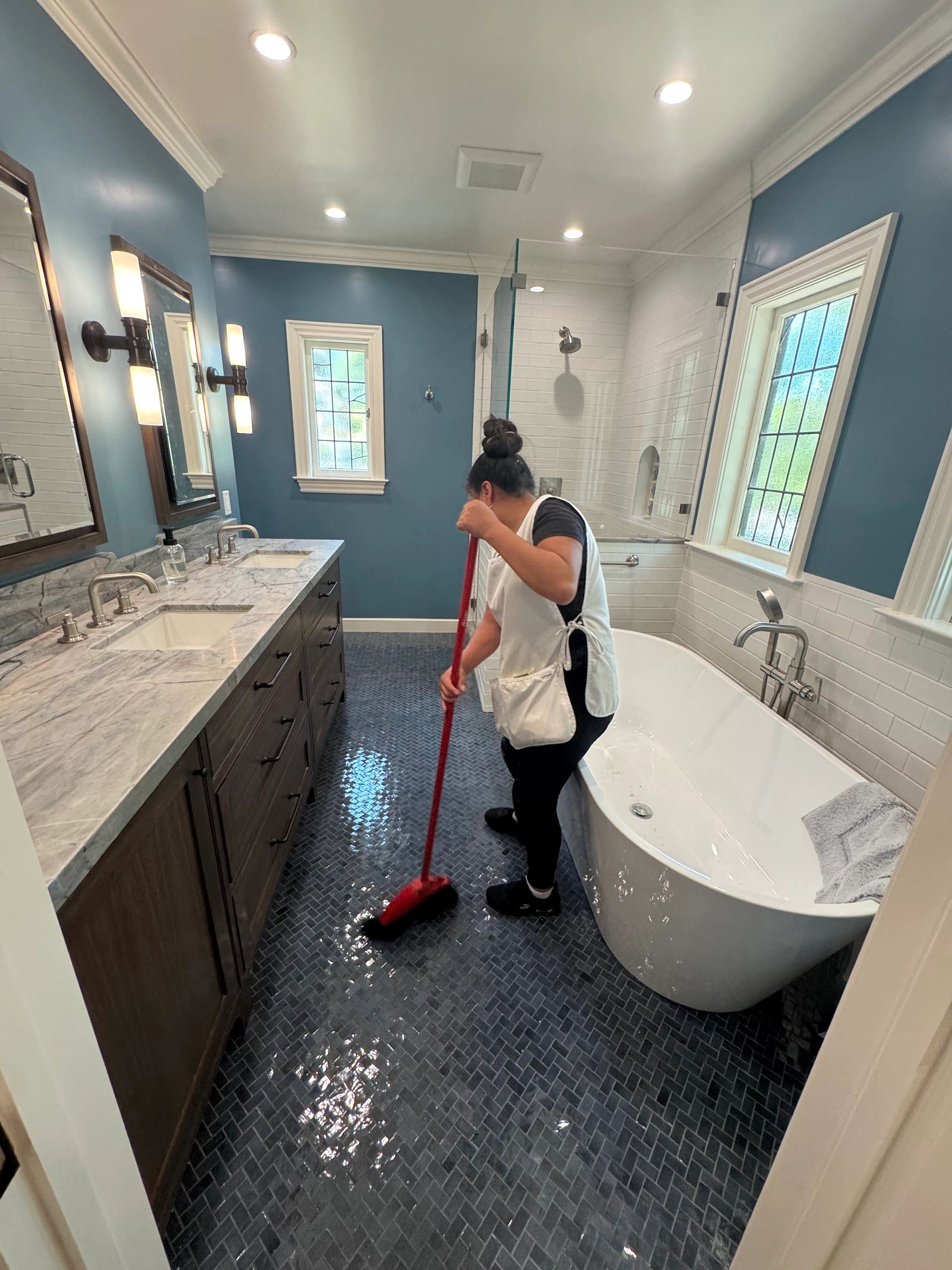 Person mopping the wet bathroom floor.