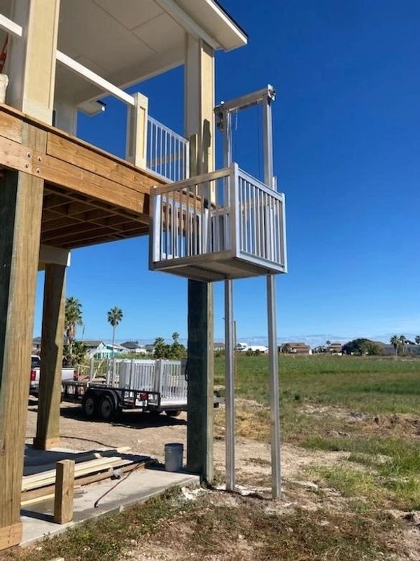 Beach house deck with aluminum cargo and freight lift installed to lift coolers and personal items.