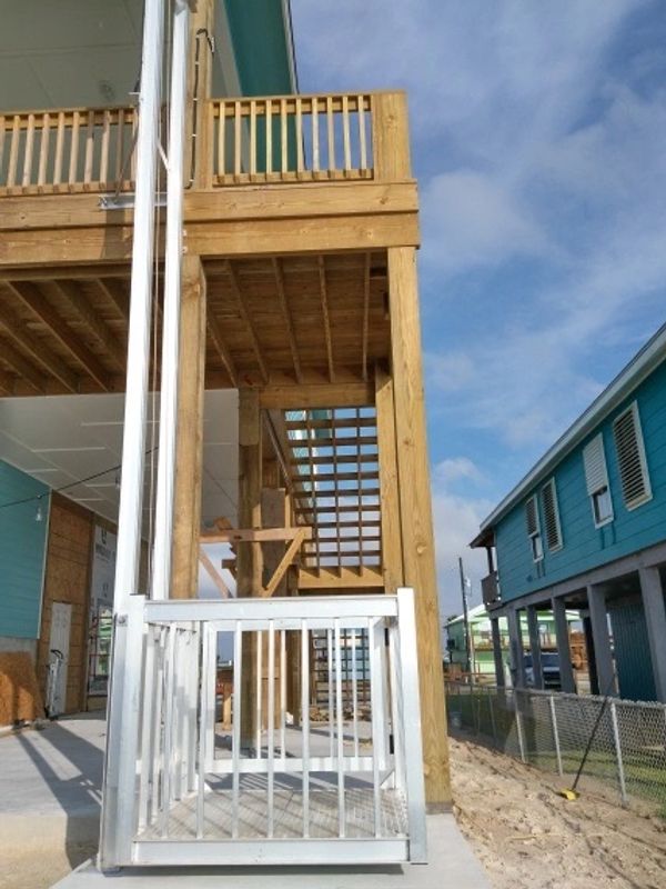 Aluminum premier series freight and cargo lift installed on a tall wooden deck.