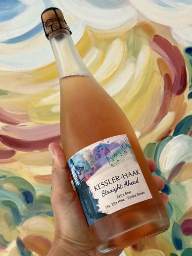 Hand holding a bottle of Kessler-Haak Straight Ahead rosé sparkling wine.