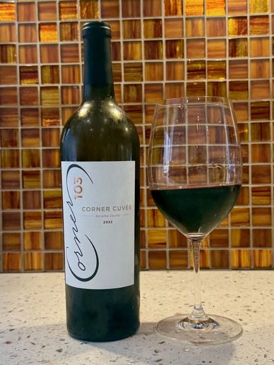 Bottle and glass of Corner Cuvée 2022 red wine.