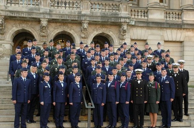 A large group of military personnel posing on stairs in uniform.