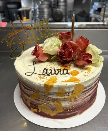 Elegant birthday cake with roses and gold accents.