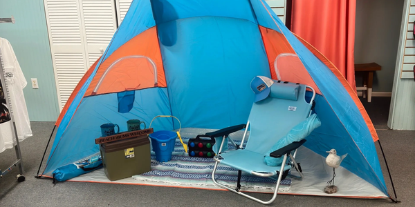 Blue and orange beach tent setup with chair and accessories indoors.