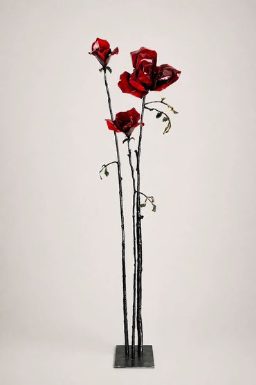 Red rose steel sculpture with tall stems, contemporary botanical art and modern floral metalwork.