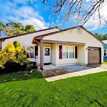 Single-story suburban house with a garage and green lawn.
