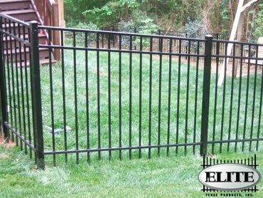 Black sliding gate made of aluminum outside a stylish home.