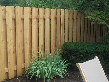 Wooden fence gate opening to a cozy residential home
