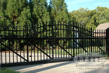 Black aluminum sliding gate with arched top, installed
