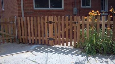 Natural wood fence gate providing access to a cozy home