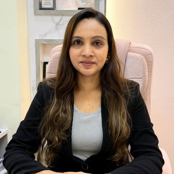 Professional woman with long hair, wearing a black blazer, sitting confidently in an office chair.