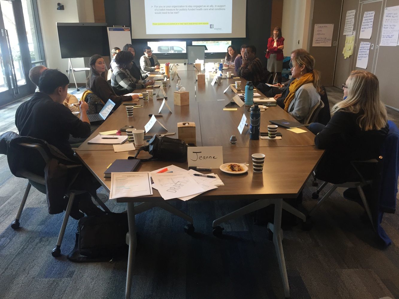 Team members sitting in a meeting room discussing ideas together