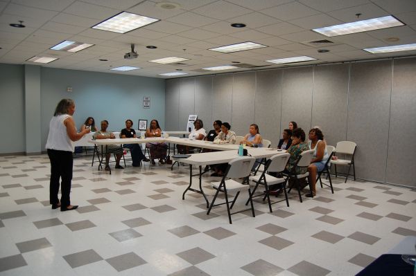 Women in a meeting room seated at tables.