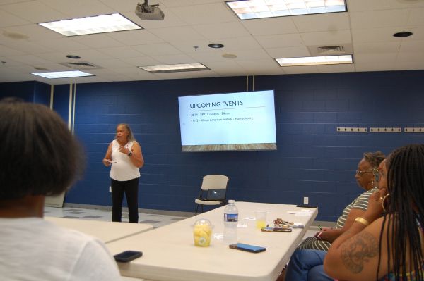Woman presenting upcoming events in a meeting room.