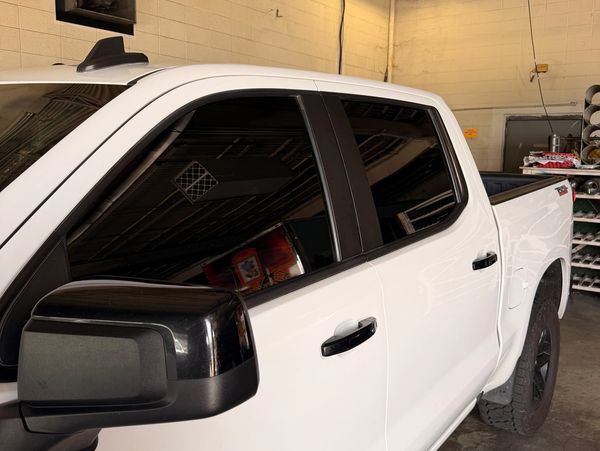 White pickup truck with tinted windows parked indoors.