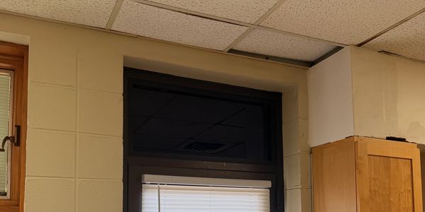 Ceiling damage visible near a ceiling tile and wall corner.