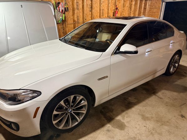 White BMW sedan parked in a garage.