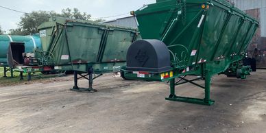 A picture of two Semi Trailers parked next to one another. One is old and one has been rebuilt. 