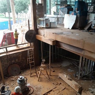 Construction workers at a multi-level building site with equipment and scaffolding.