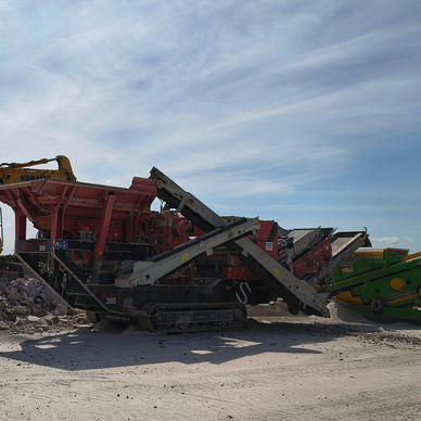 Heavy machinery at a construction site under a partly cloudy sky.