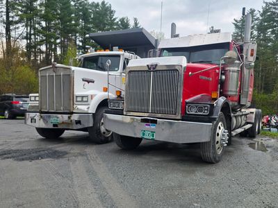 Two big semi trucks parked side by side.