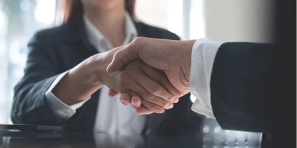 Two business professionals shaking hands in agreement.