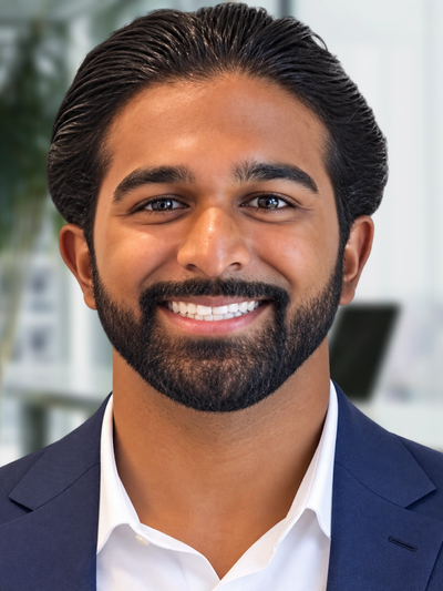 Man in a suit smiling warmly.