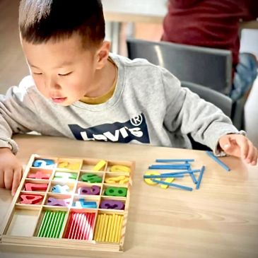 Child playing with educational colorful numbers and sticks.