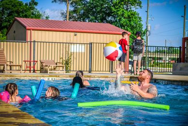 East Fork RV Resort community pool area with lounge chairs and umbrellas
