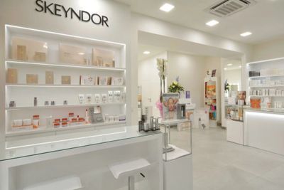 Modern skincare store with sleek white shelves and products.