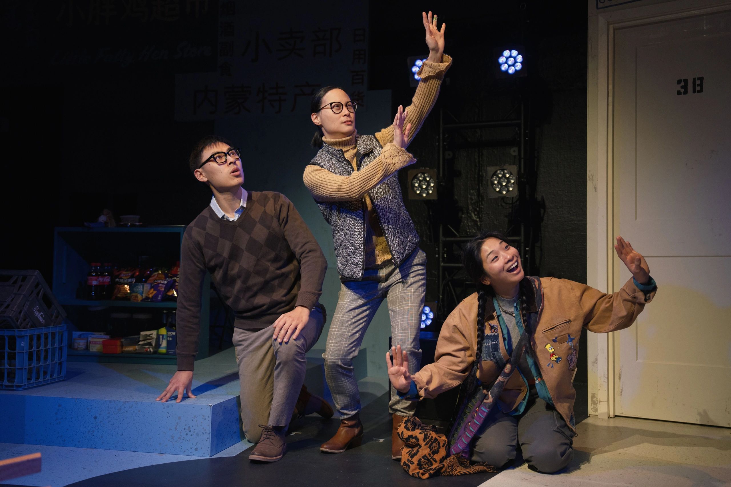 Three people striking expressive poses on stage during a performance.