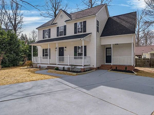 Two-story white house with a large driveway.