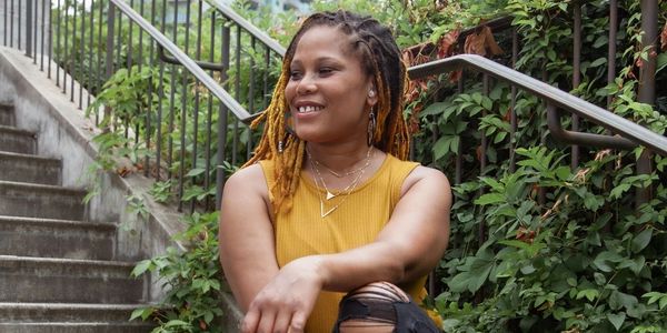 woman sitting on stairs looking right and smiling