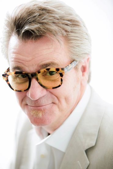 Man with stylish glasses and gray hair.
