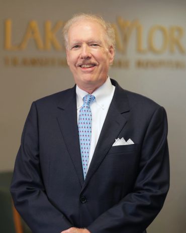 Professional older man in suit smiling.