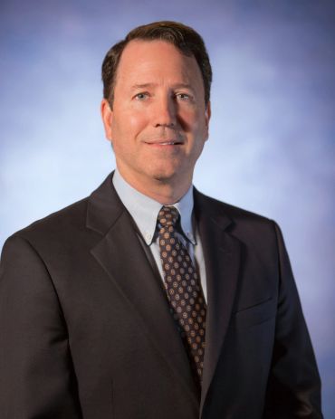 Man in a business suit posing for a portrait.