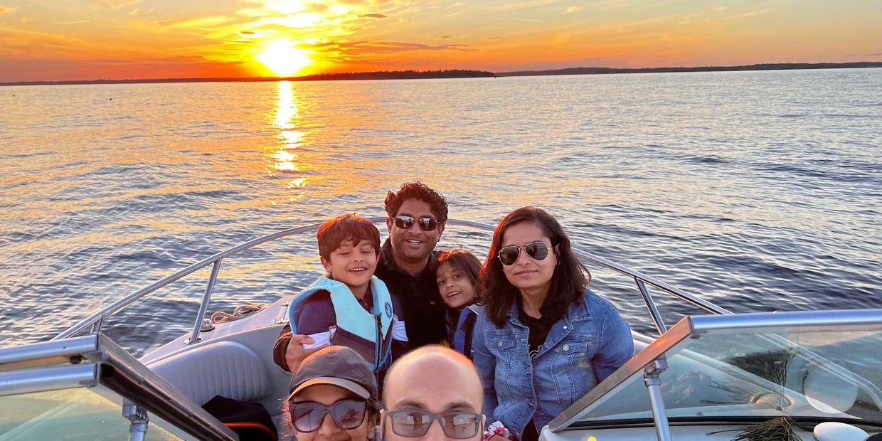 2 couple and 2 kids posing in front of the sunset on a Casco Bay boat cruise
