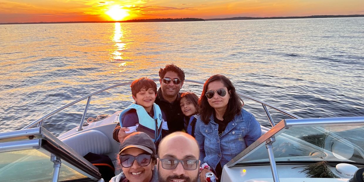 2 couple and 2 kids posing in front of the sunset on a Casco Bay boat cruise